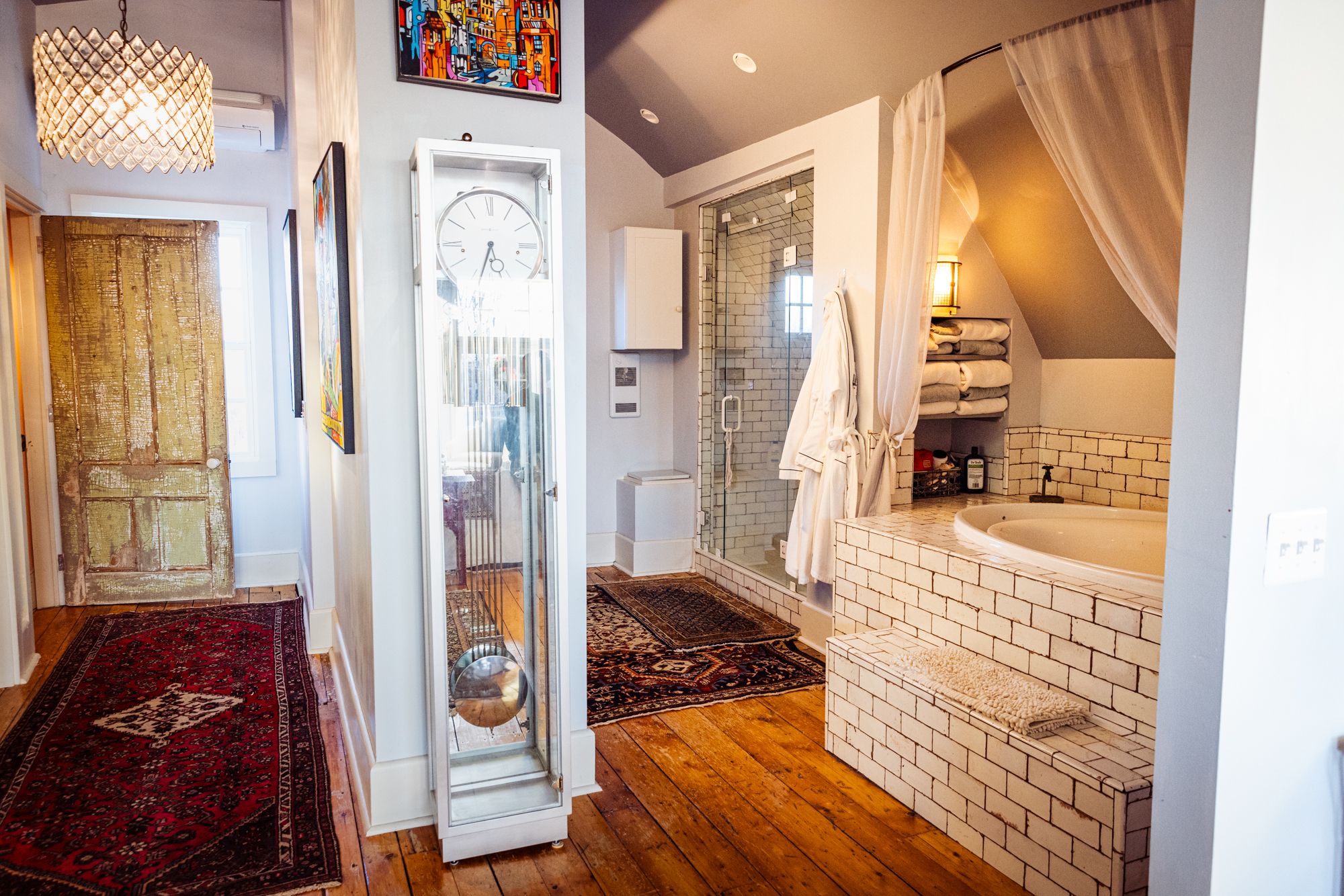 A soaking tub and subway-tiled bath